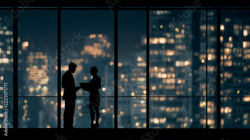Business Meeting Silhouette with City Lights at Night in Office