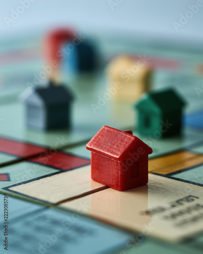 Monopoly house pieces on property board game close up  