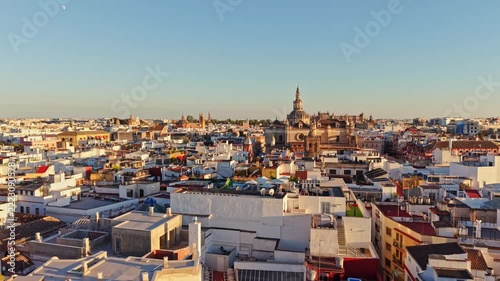 Drone view across the white rooftops of Seville toward the cathedral in the morning light, Spain.