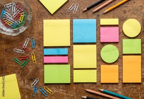 Sticky notes and paperclips on wooden desk