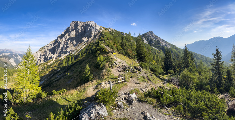 Naklejka premium Scenic view of mountain peak Hochturm in Hochschwab region, Styria, Austria. Steep rocky cliffs covered in deciduous trees in vibrant autumn colors. Wanderlust Austrian Alps.