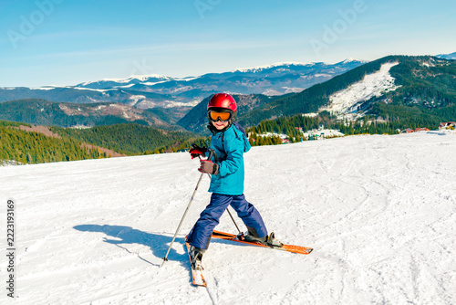 Active kid boy riding downhill,learn skiing in mountains alpine winter resort.little child enjoy extreme sport activities recreation,family luxury vacation