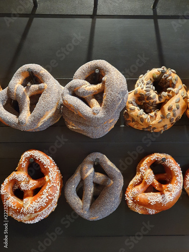 Artisan Pretzels Hanging On Pegs In Bakery Display Wall With Seeded And Salted Varieties