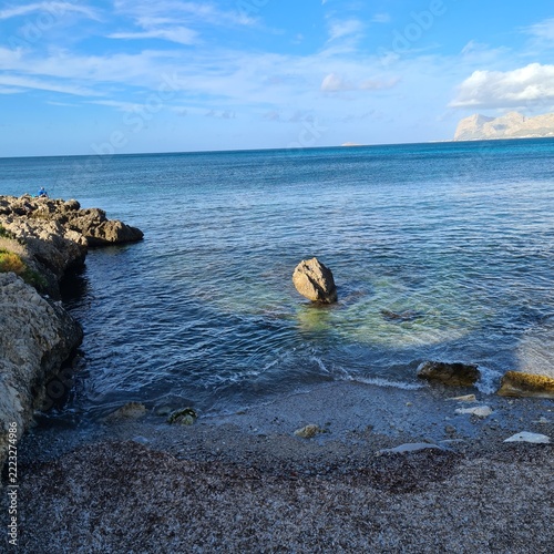  Peaceful coastal scene with transparent turquoise waters, rocky formations and distant mountains. Natural seascape ideal for travel, tourism and outdoor lifestyle concepts.
