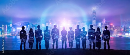 silhouettes of business people with digital connections at night
