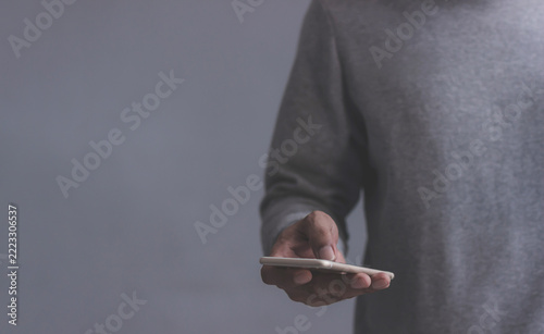 Young man using smartphone to select and interact with digital content for business.