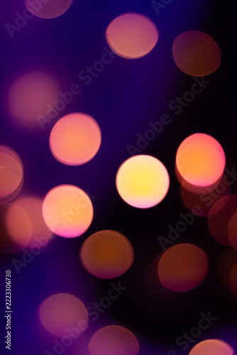 Abstract orange and golden bokeh lights glowing against a dark background creating a warm atmosphere.