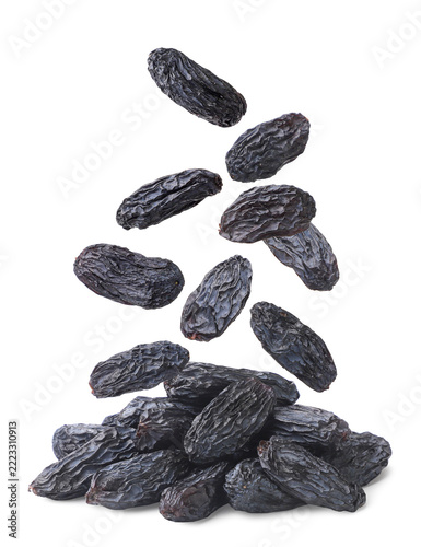 Raisins falling on a pile close-up on a white. Isolated