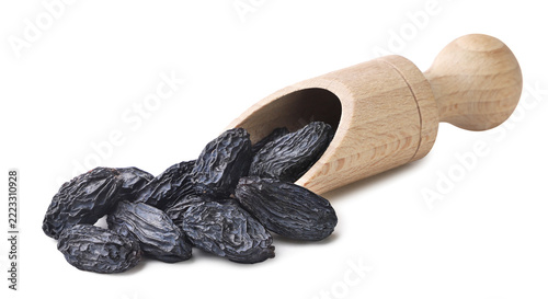Raisins spilled from a wooden scoop on a white. Isolated
