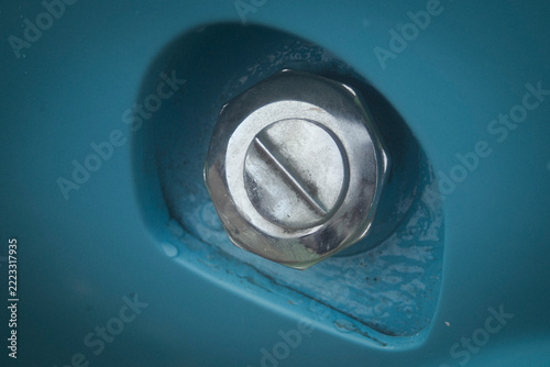 shot of a vintage blue car chrome fuel tank cap.
A high-quality close-up macro photograph focusing on the classic chrome or stainless steel gas fuel filler cap of a vintage retro automobile. 