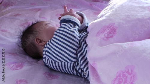 タイムラプスで撮影した家のベッドの上にいる可愛い新生児の赤ちゃんの遊ぶ様子