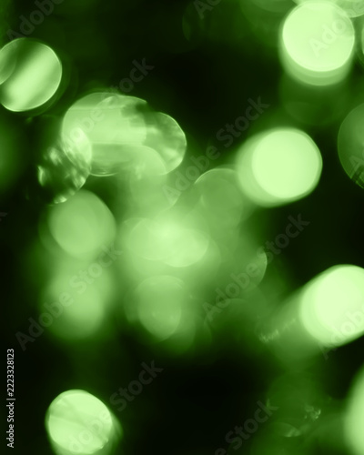Green bokeh lights abstract background, glowing circles for festive celebration