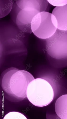 Purple bokeh lights background. Abstract glowing blurred circles for festive holiday party design