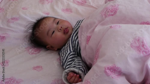 タイムラプスで撮影した家のベッドの上にいる可愛い新生児の赤ちゃんの遊ぶ様子