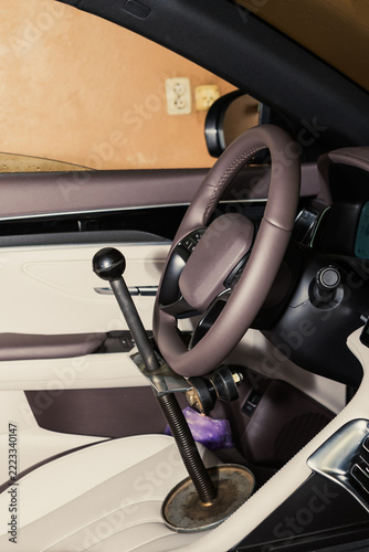 Mechanism for fixing the steering wheel. Unique vehicle modification shows steering wheel and custom gear shifter in car interior during the day