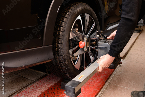 Wheel alignment and alignment on the car service platform. Car tire alignment process takes place in a vehicle service center during the afternoon