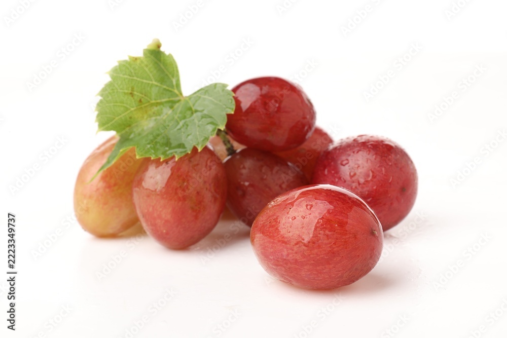 Fototapeta premium Fresh ripe grapes with green leaf on white background