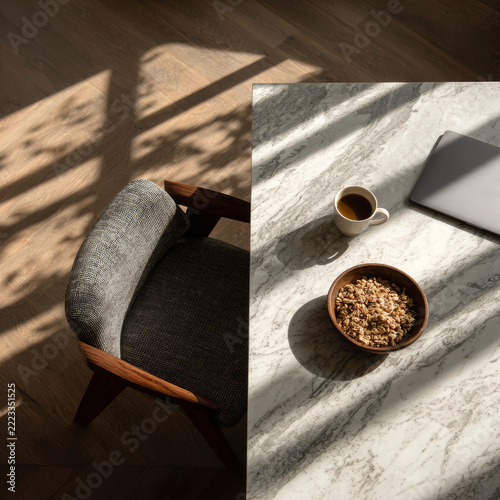 Granola bowl with coffee and laptop on marble table in sunny morning interior