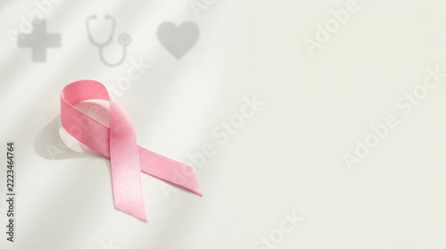 Pink ribbon symbol for breast cancer awareness, accompanied by essential medical icons on a light background.