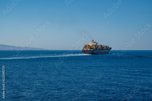 A cargo ship crosses the Strait of Messina (Italy)