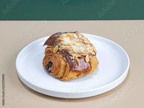 Golden-brown croissant, generously topped with sliced almonds