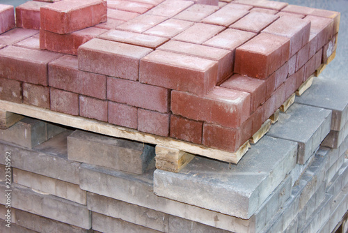 Construction sidewalk pavers on pallets, bricks on pallets for building sidewalks, paths, and walkways, and for landscaping. Blocks on pallets for sidewalk construction.