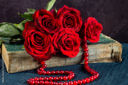 still life with red roses, burning candles, old fashioned books, books and flowers. still life, romantic, love, romantic concept. valentines