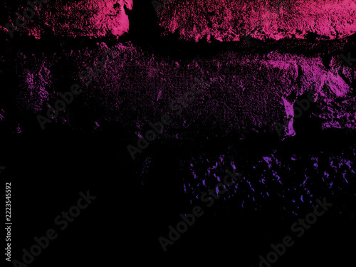 Dark aged brick masonry wall illuminated by vivid magenta and purple neon glow light in a moody night city setting with high contrast shadows
