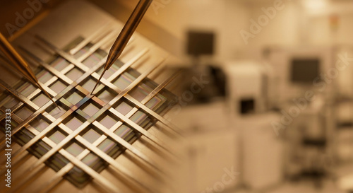 A precision microprobe testing station contacts a memristive crossbar array chip inside a semiconductor cleanroom laboratory for advanced neuromorphic computing research