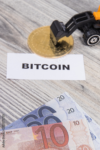 Bitcoin, miniature excavator and euro bills. Cryptocurrency. International network payment. Finance concept