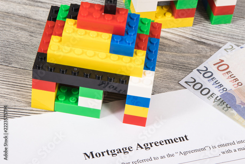 Houses made of toy blocks, mortgage agreement form and euro banknotes. Method of financing building or purchase of real estate