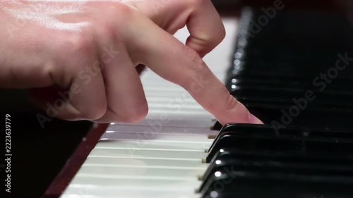 Slow Touch Keyboard Piano. Female fingers close-up slowly touch the piano keys, extracting a simple melody