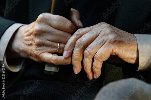 Wrinkled Hands Of Elderly Man Holding Microphone At Public Event Close Up