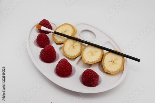 Fotografie Creative Fruit Art Palette with Fresh Raspberries, Banana Slices and Paintbrush