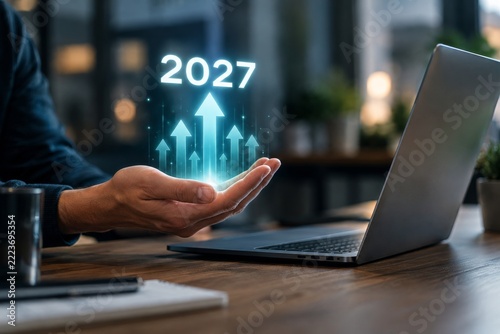 Hand Presenting Glowing Turquoise Arrows beside a Laptop in a Dim Office