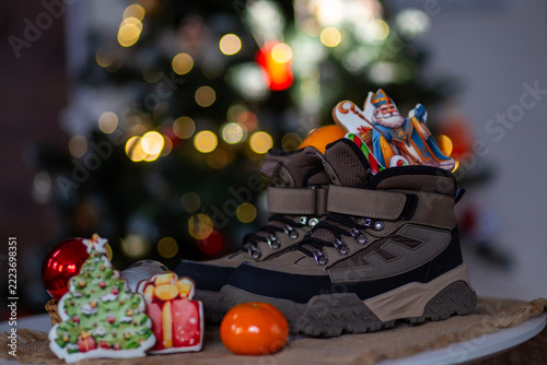 Christmas Stockings and Gifts Inside Winter Boots, Festive Bokeh Background. Colorful holiday treats tucked inside winter boots.