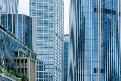 Close up of modern glass skyscraper facades with windows, vertical lines and geometric forms in Shenzhen, China. Abstract architecture background, reflective glass texture, facade pattern