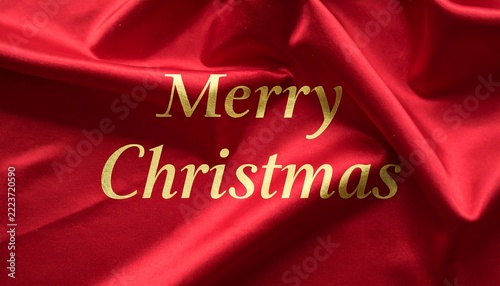 Merry Christmas greeting text on red fabric background