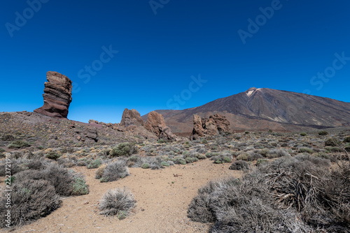 Roque Cinchado rock formation and Teide volcano under a blue sky, Tenerife, Canary Islands, Spain.