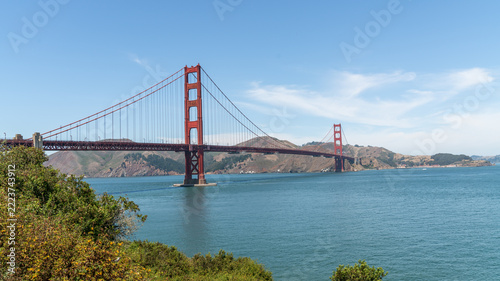 Golden Gate Bridge, San Francisco, California, USA, the red suspension bridge crossing the Golden Gate strait toward the Marin Headlands, framed by coastal shrubs