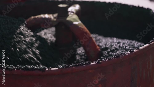 Rubber crumb mixture being stirred in container for flooring installation