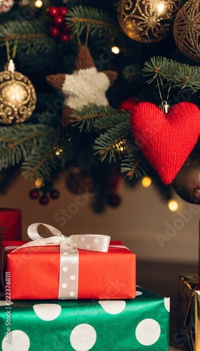 Christmas Gift Boxes under Decorated Christmas Tree with Warm Fairy Lights Concept