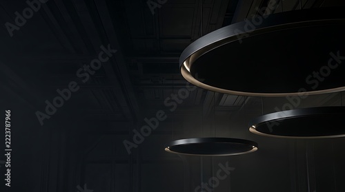 Modern minimalist pendant lights with glowing circular rims in a dark industrial architectural interior space