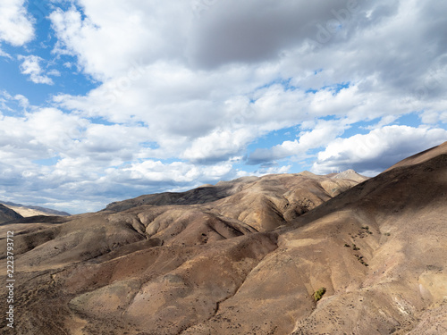 Sunlit mountain ridges stretch under dynamic clouds