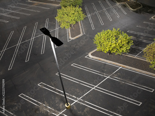 Aerial photo of deserted parking area with white lines and greenery