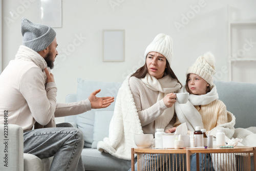 Ill family in warm hats treating cold at home