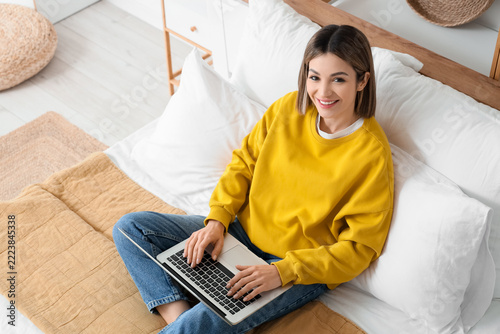 Remote work and digital nomad lifestyle, happy woman using a laptop while sit...
