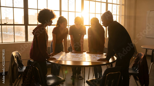 A diverse group of colleagues collaborating around a round table with a projected display