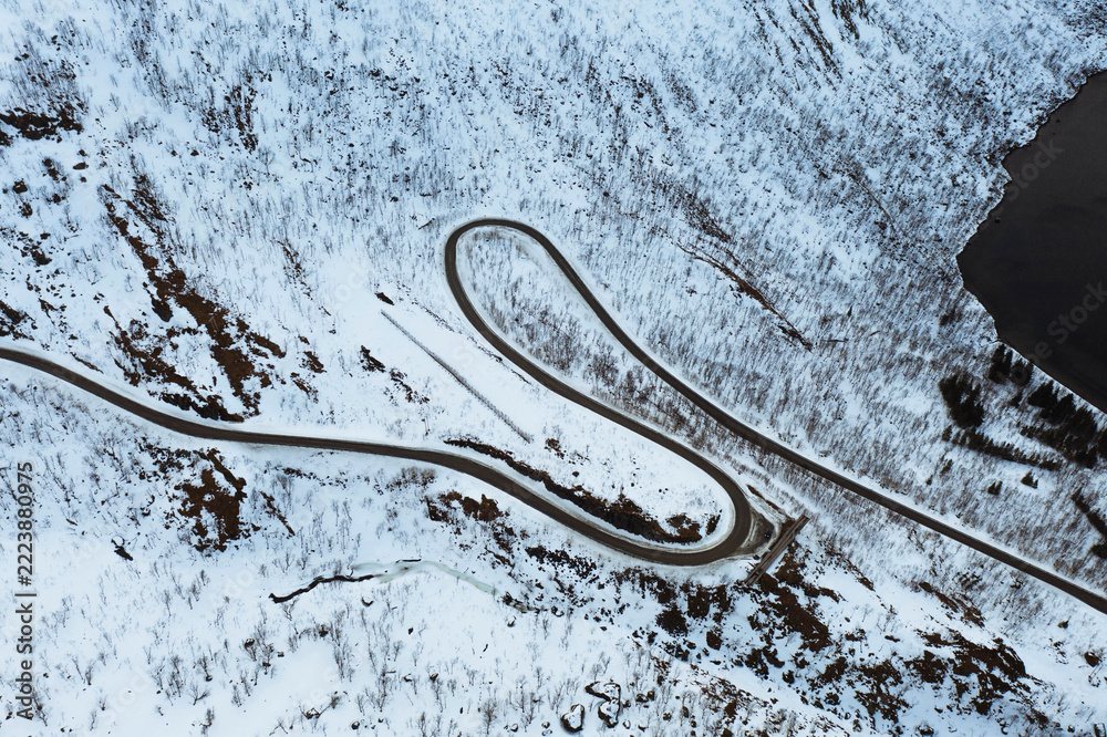 Fototapeta premium Drone shot of a snowy winding road in Norway