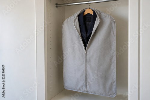 Navy Coat Inside a Partly Open Gray Garment Cover